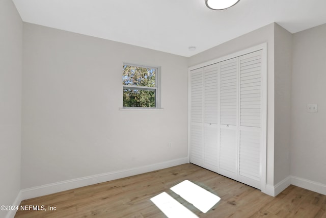 unfurnished bedroom featuring light hardwood / wood-style floors and a closet