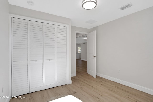 unfurnished bedroom with a closet and light hardwood / wood-style flooring