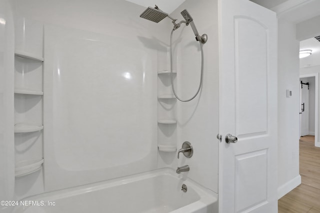 bathroom featuring shower / bathing tub combination and hardwood / wood-style flooring