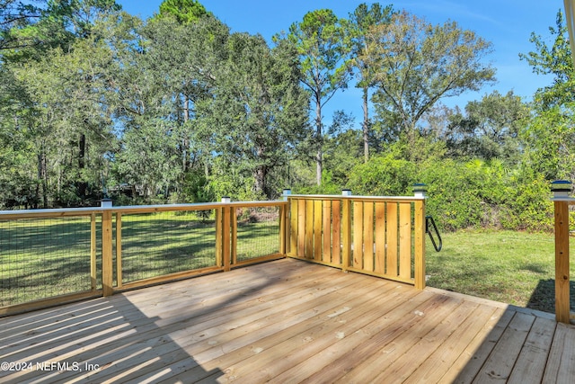 wooden terrace featuring a lawn