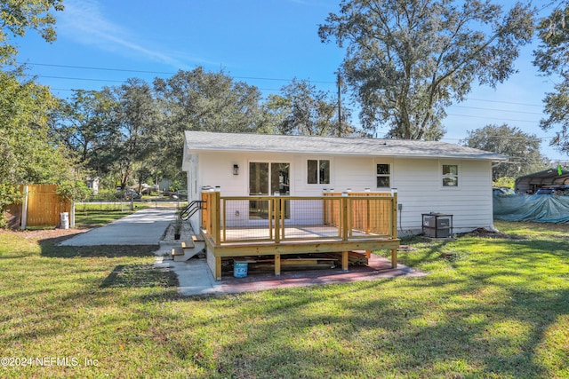 rear view of property featuring a deck and a lawn