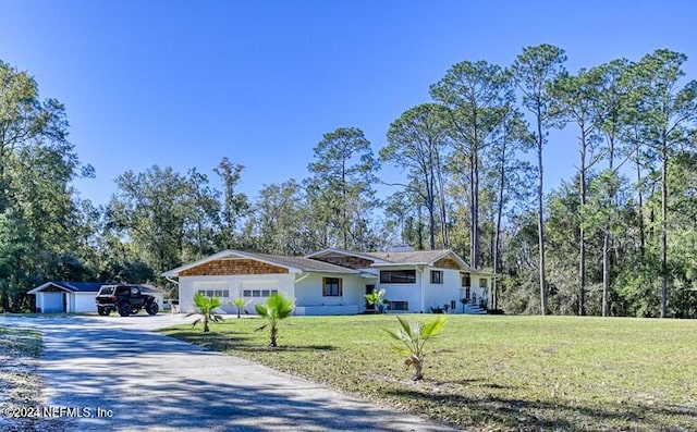 view of front of property featuring an outdoor structure and a front yard