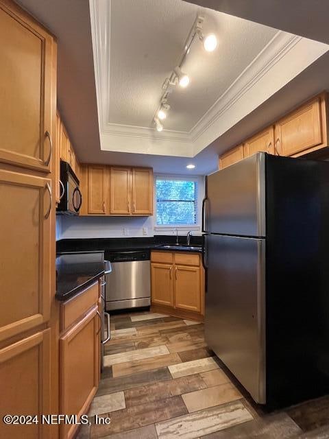 kitchen featuring light wood-type flooring, track lighting, crown molding, sink, and black appliances