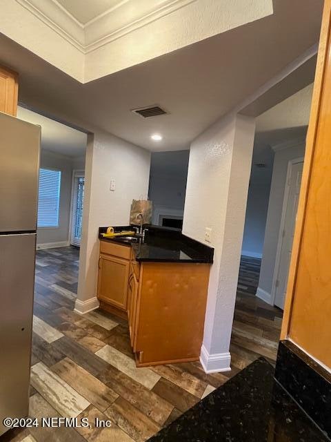 kitchen featuring stainless steel fridge, sink, crown molding, and dark hardwood / wood-style floors