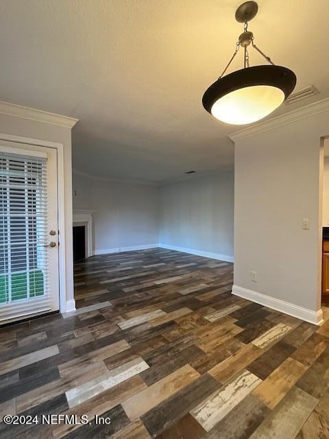 spare room featuring dark hardwood / wood-style floors and ornamental molding