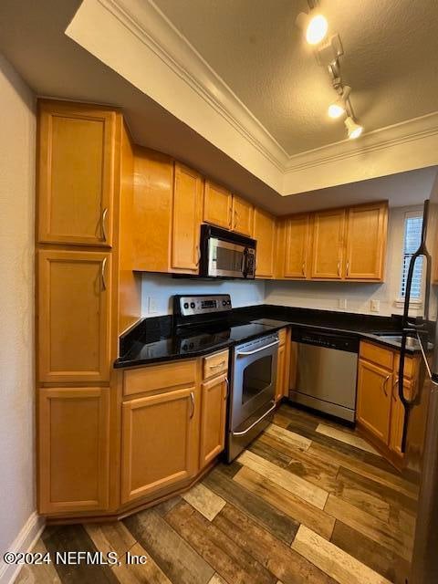 kitchen featuring track lighting, crown molding, dark hardwood / wood-style floors, a textured ceiling, and appliances with stainless steel finishes