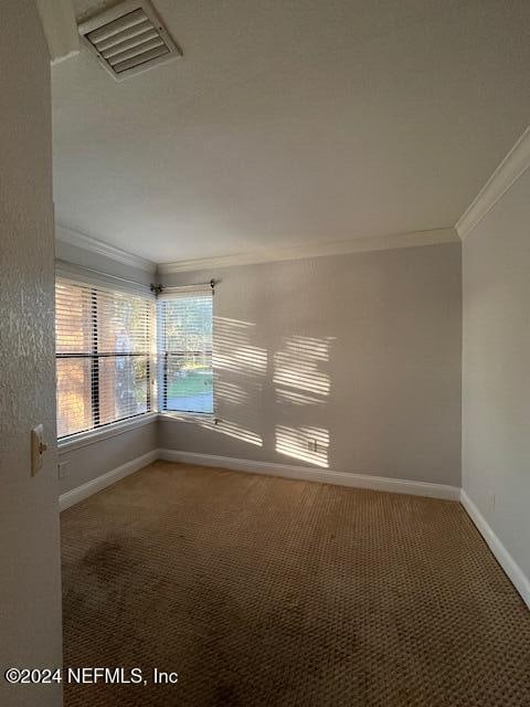 carpeted spare room with crown molding