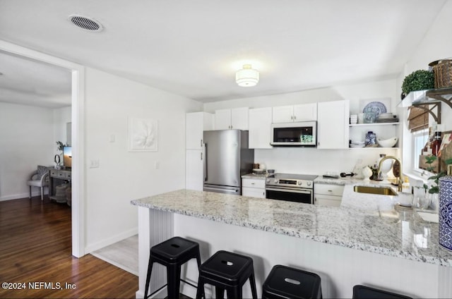 kitchen featuring white cabinets, sink, kitchen peninsula, and stainless steel appliances