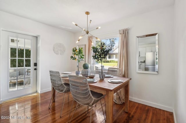 dining area with wood-type flooring and a notable chandelier