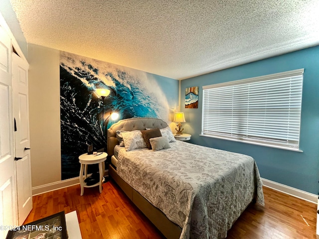 bedroom featuring a textured ceiling and dark wood-type flooring