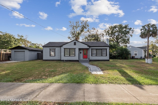 view of front of home with an outbuilding, a front yard, and a garage