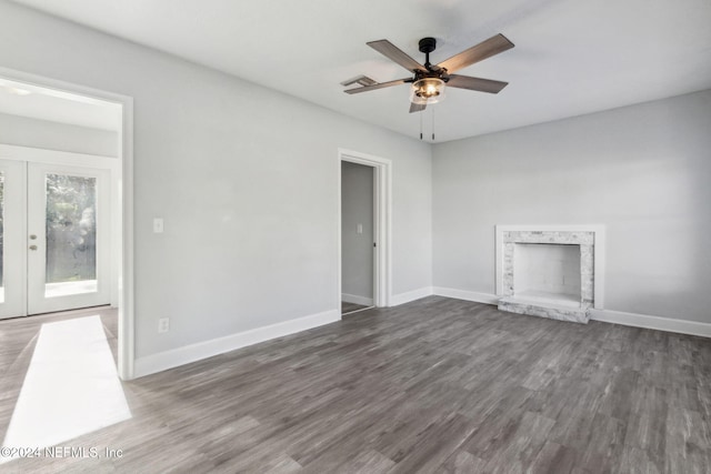 unfurnished living room featuring french doors, ceiling fan, and dark wood-type flooring