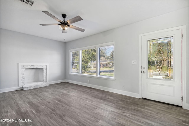 unfurnished living room featuring dark hardwood / wood-style flooring and ceiling fan