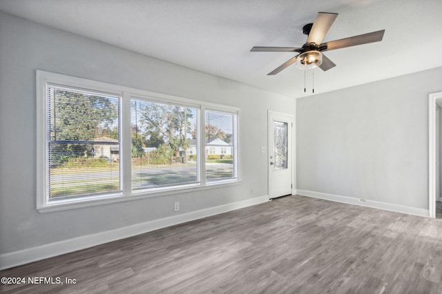 unfurnished room with ceiling fan and dark hardwood / wood-style flooring