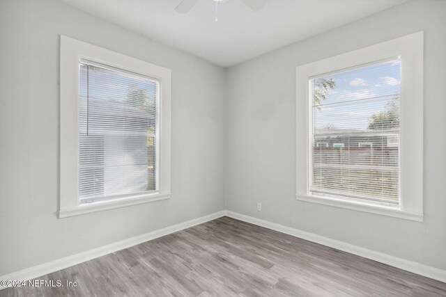 empty room featuring hardwood / wood-style flooring, plenty of natural light, and ceiling fan