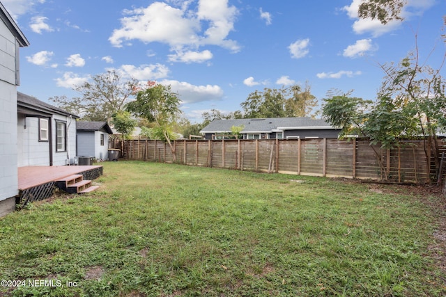 view of yard with central AC unit and a wooden deck