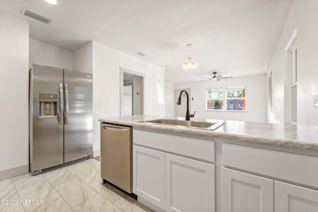 kitchen with white cabinetry, sink, ceiling fan, hanging light fixtures, and stainless steel appliances