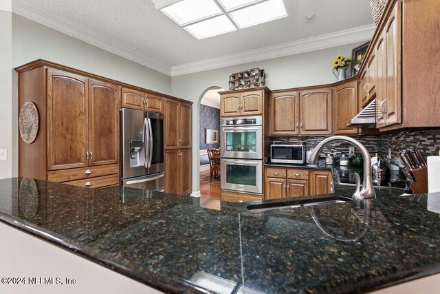 7436 Woodlawn Rd, Macclenny, FL 32063 - kitchen featuring kitchen peninsula, stainless steel appliances, crown molding, and sink