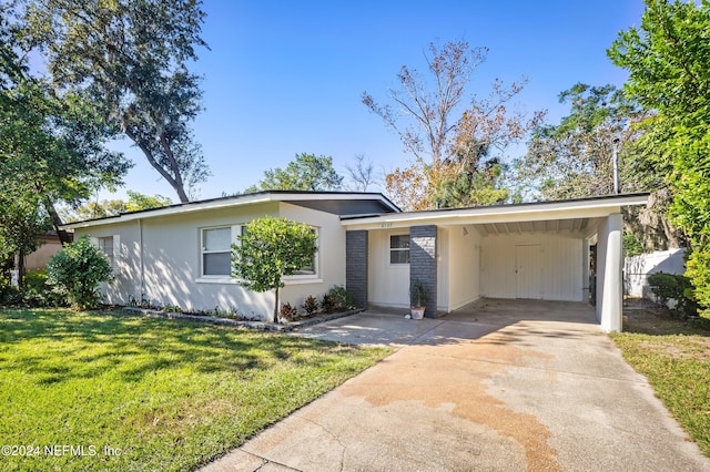 single story home featuring a carport and a front lawn