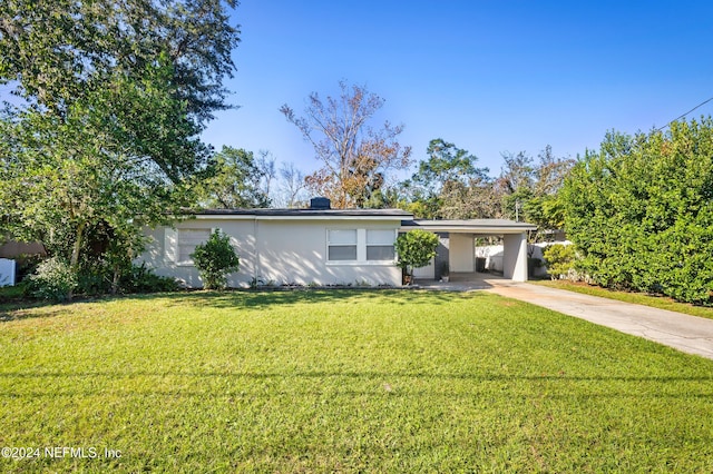 single story home featuring a carport, a front yard, concrete driveway, and stucco siding