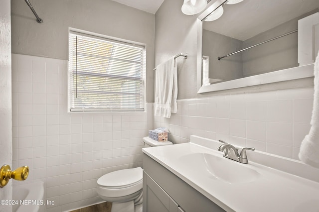 full bath featuring wainscoting, toilet, vanity, shower / washtub combination, and tile walls