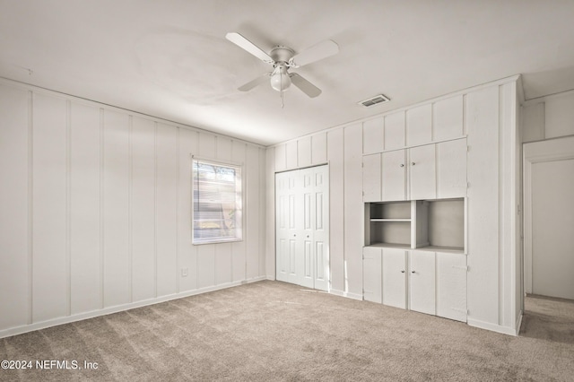 unfurnished bedroom featuring ceiling fan, a closet, visible vents, and light colored carpet