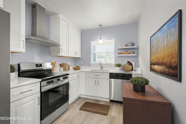 kitchen featuring stainless steel appliances, light countertops, white cabinets, and wall chimney exhaust hood