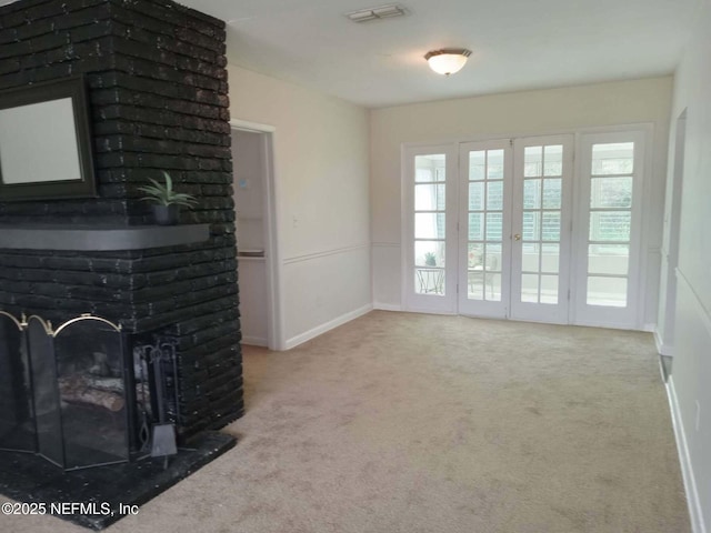 carpeted living area featuring a brick fireplace, visible vents, and baseboards