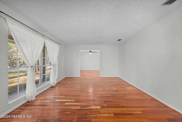 unfurnished room with hardwood / wood-style flooring, ceiling fan, and a textured ceiling