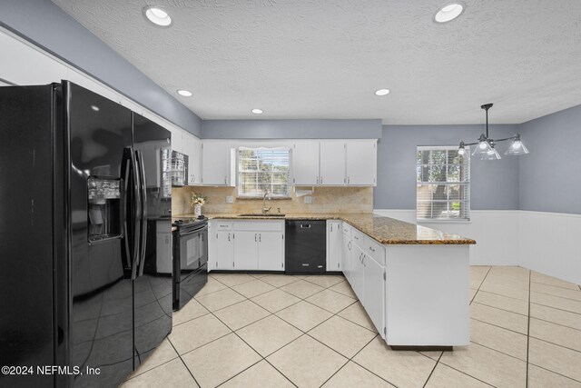 kitchen featuring decorative backsplash, black appliances, pendant lighting, stone countertops, and white cabinetry