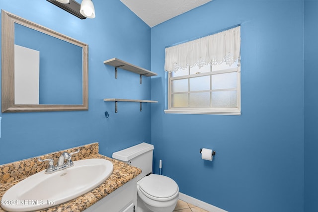 bathroom featuring tile patterned flooring, vanity, a textured ceiling, and toilet