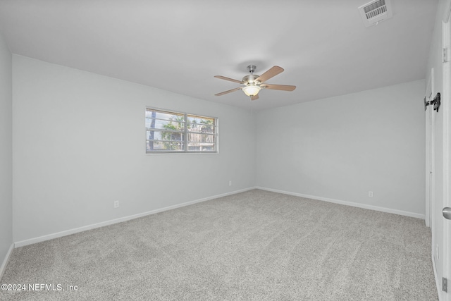 carpeted spare room with ceiling fan