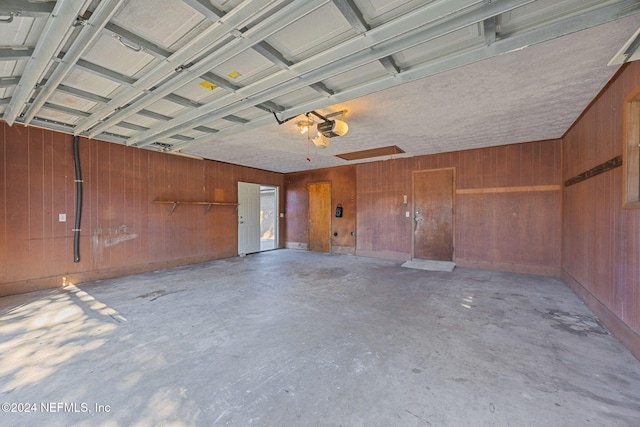 garage featuring wooden walls and a garage door opener