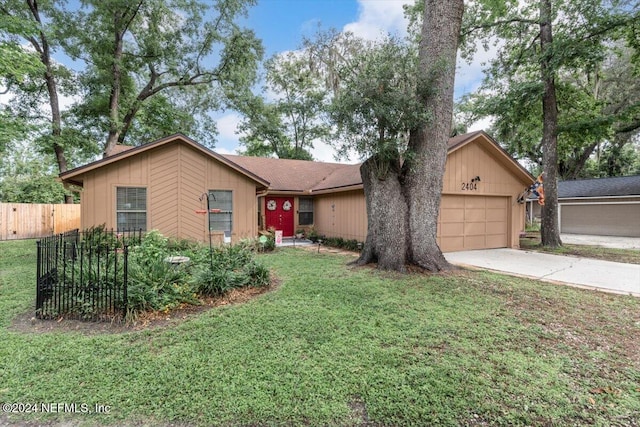 single story home featuring a garage and a front lawn