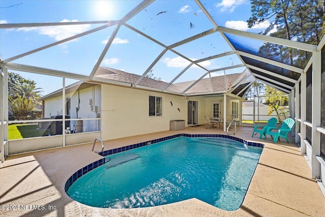 view of swimming pool with glass enclosure and a patio