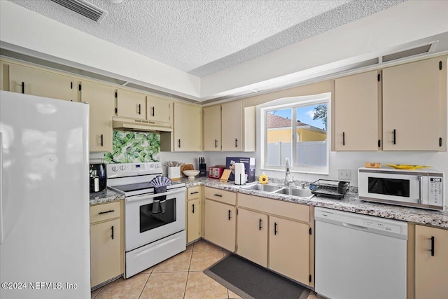 kitchen with white appliances, cream cabinets, sink, a textured ceiling, and light tile patterned flooring