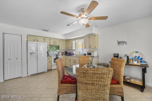 dining room featuring sink, light tile patterned floors, and a textured ceiling