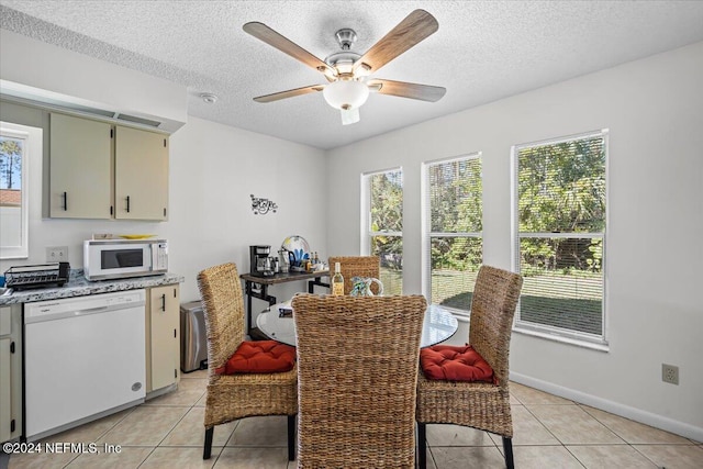 dining area with ceiling fan, light tile patterned floors, and a textured ceiling