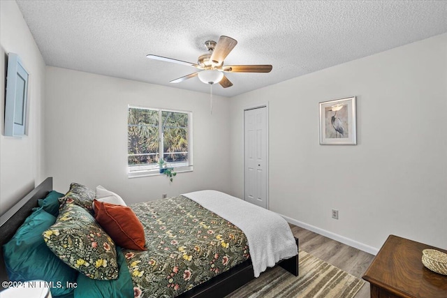 bedroom featuring a closet, ceiling fan, hardwood / wood-style floors, and a textured ceiling