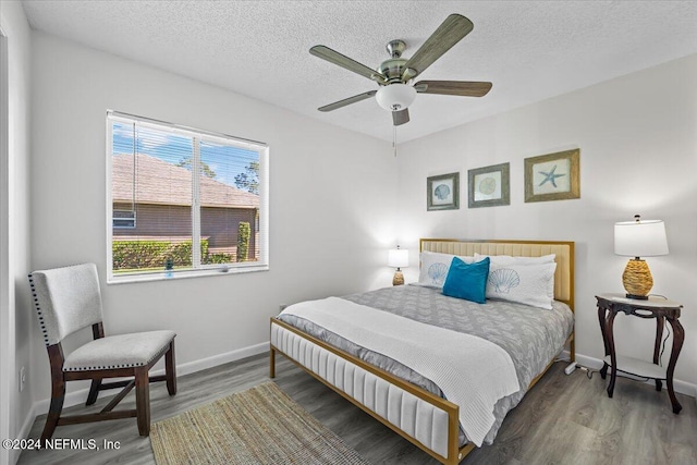 bedroom featuring a textured ceiling, ceiling fan, and dark hardwood / wood-style floors