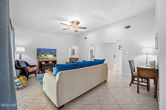 tiled living room featuring a textured ceiling and ceiling fan