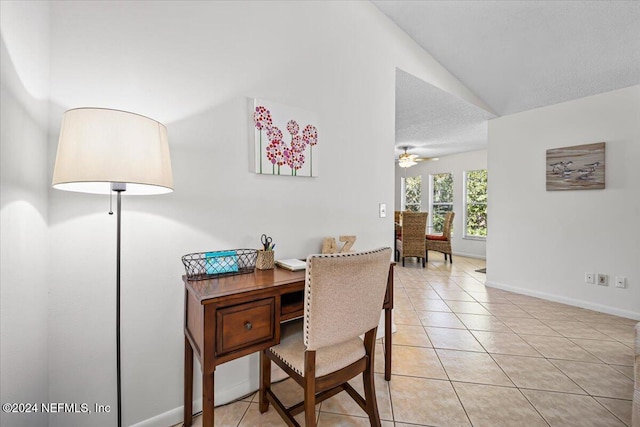 office featuring ceiling fan, light tile patterned flooring, and lofted ceiling