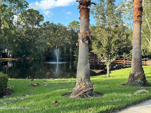 view of property's community featuring a yard and a water view