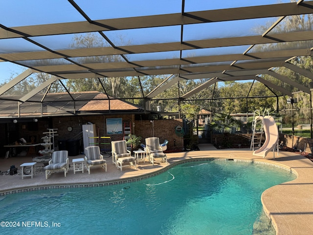 view of pool featuring a patio area, a lanai, and a water slide