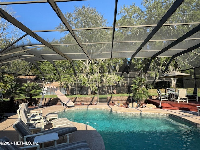 view of swimming pool with glass enclosure and a patio area