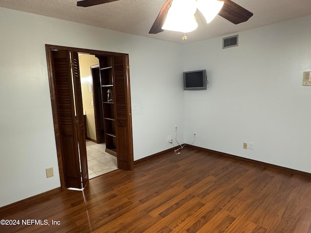 spare room with ceiling fan, light hardwood / wood-style flooring, and a textured ceiling