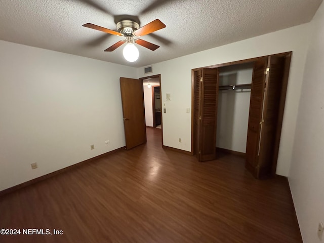 unfurnished bedroom featuring a closet, a textured ceiling, dark hardwood / wood-style floors, and ceiling fan