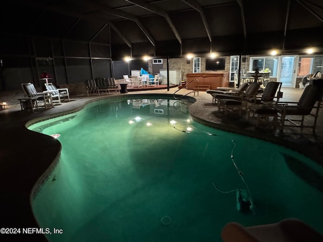 view of swimming pool with glass enclosure, a patio, and a hot tub