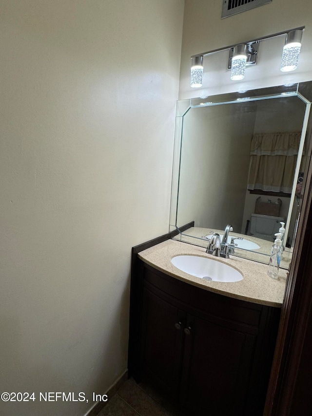 bathroom featuring tile patterned flooring, vanity, and toilet