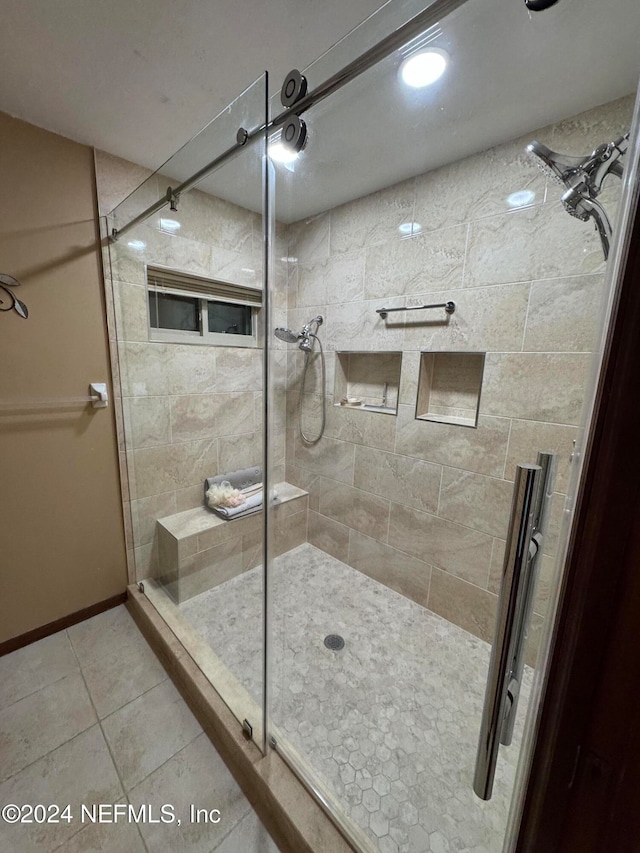 bathroom with tile patterned floors and a shower with shower door